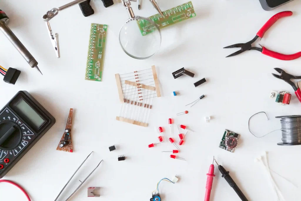 Components sourcing flat lay showing electronic parts and tools for PCB assembly